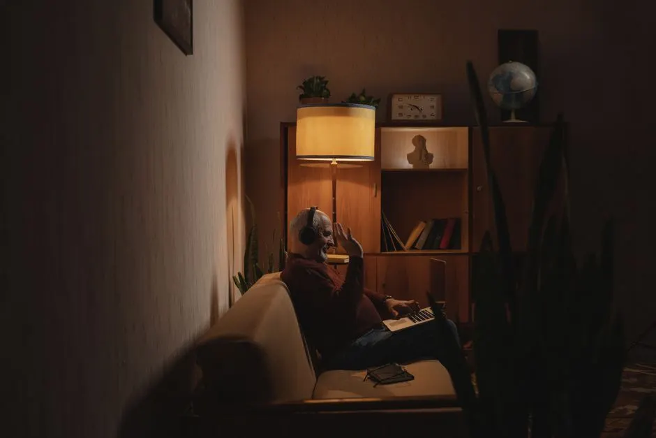 Habitación en penumbra con alguien iluminado por la pantalla del portátil