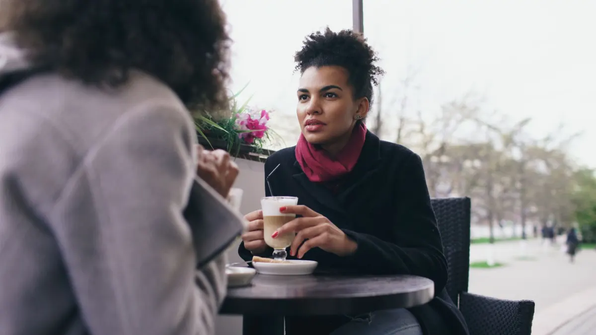Dos mujeres charlando con un café en una terraza